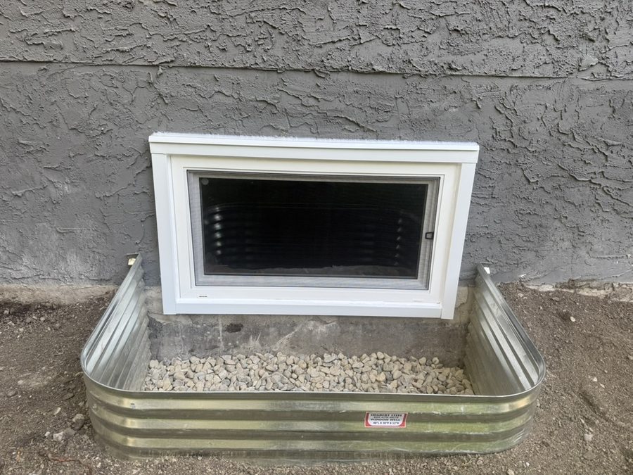 Hopper egress window with galvanized window well — finished exterior Calgary