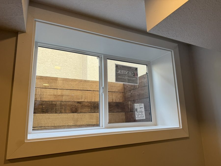 Interior finished egress sliding window with white casement trim and frame