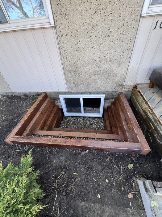 Staged cedar and PT wood window well — aerial view of finished installation
