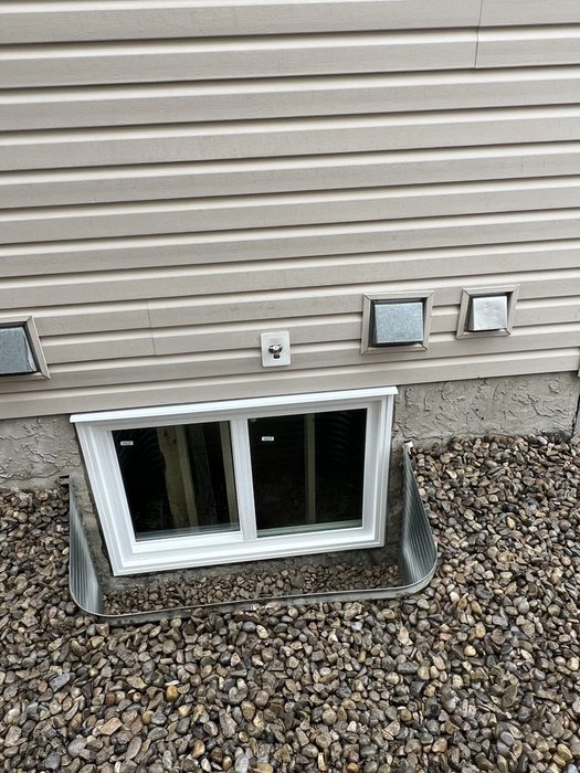 Completed egress sliding window with galvanized well installation — Calgary