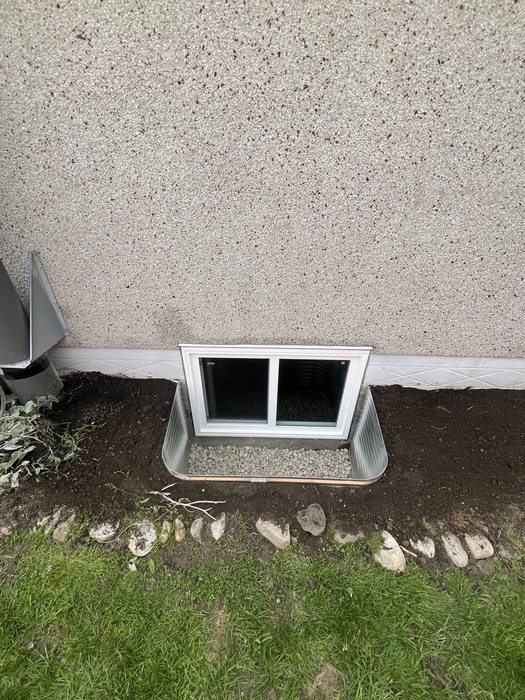 Egress sliding window with galvanized well on stucco home — Calgary