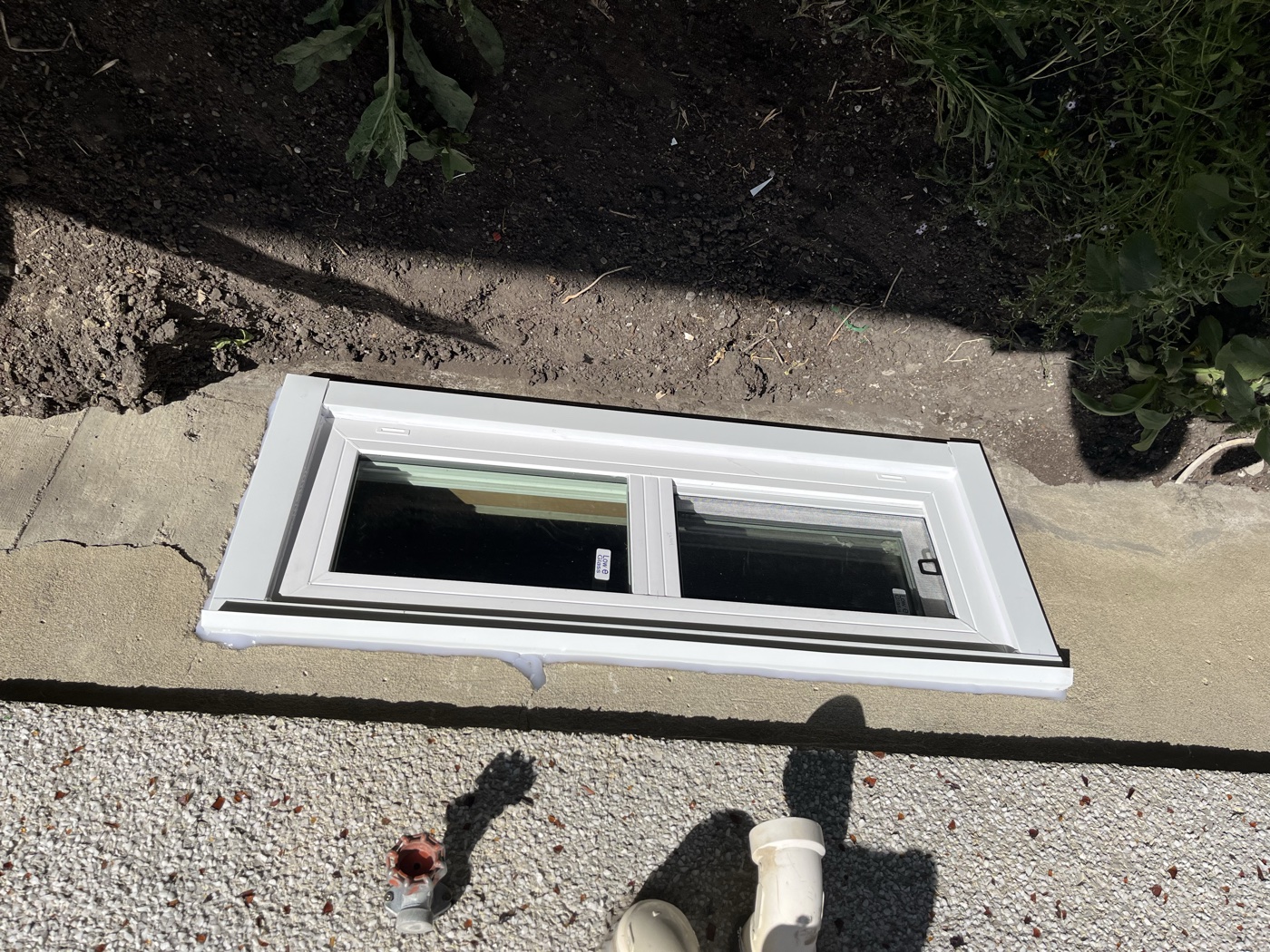 Completed egress window installation replacing old basement window — Calgary