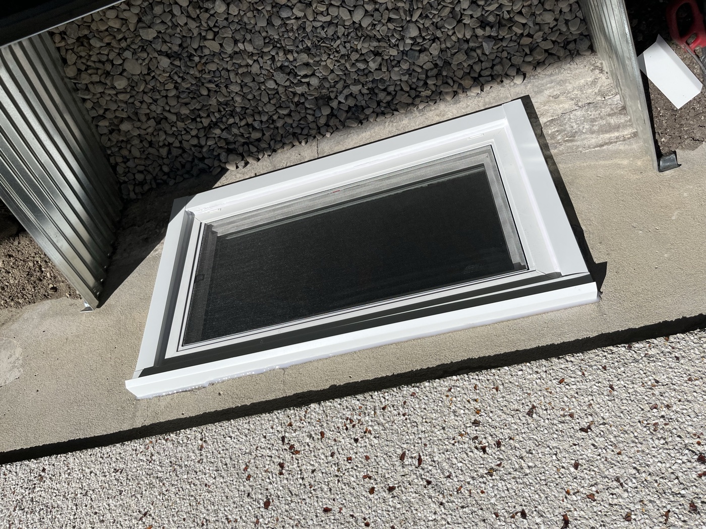 Finished egress window with galvanized well — Calgary home exterior