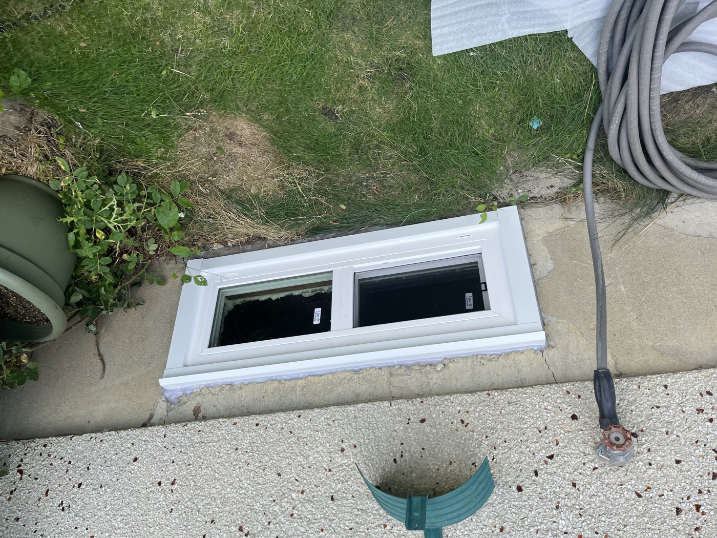 Egress window installed exterior — Calgary basement upgrade complete