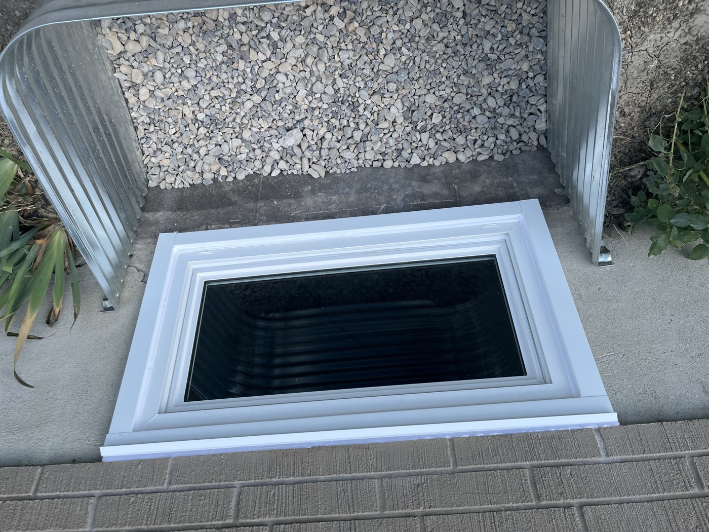 Galvanized window well with completed egress window — Calgary home