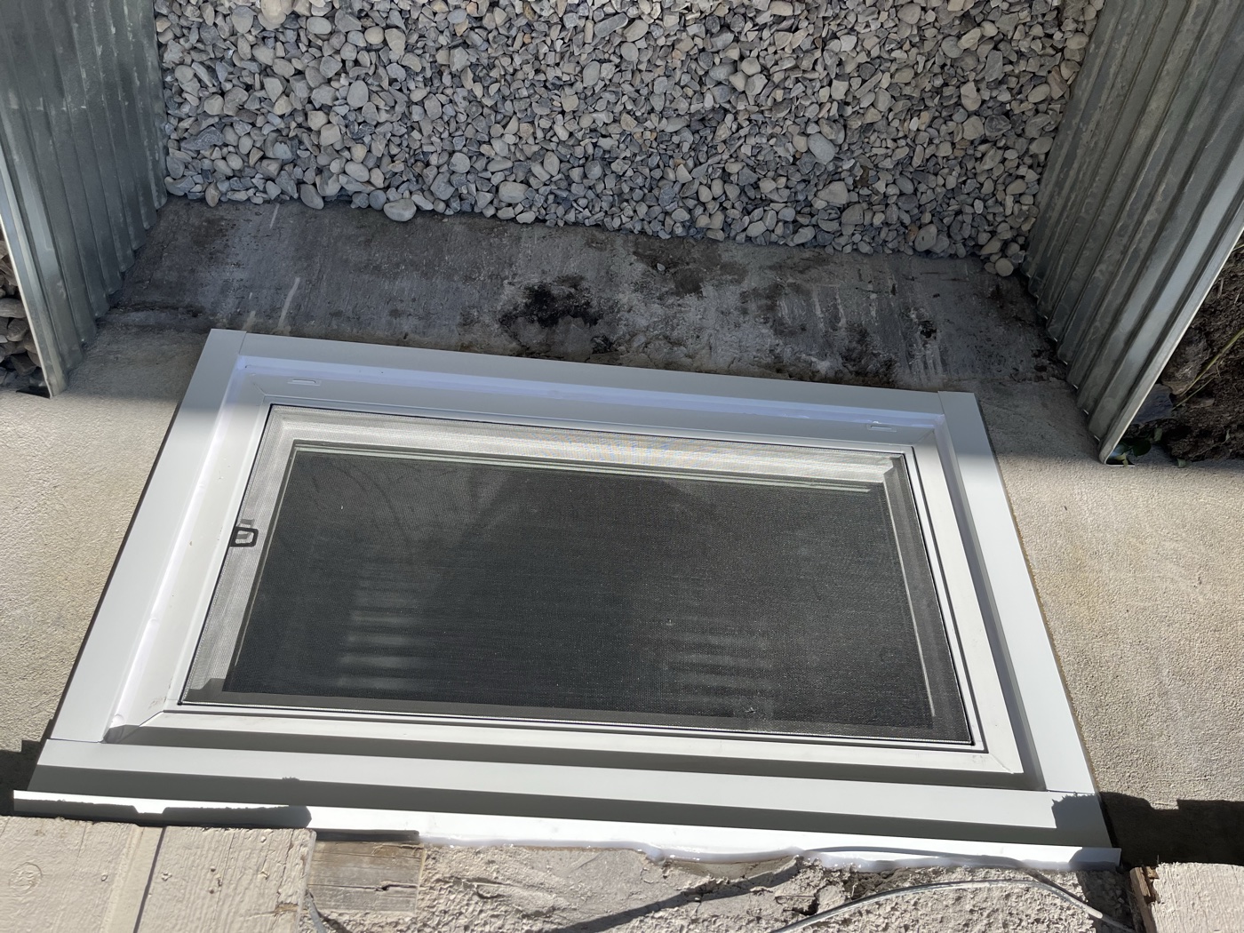 Completed egress window installation — exterior finished, Calgary