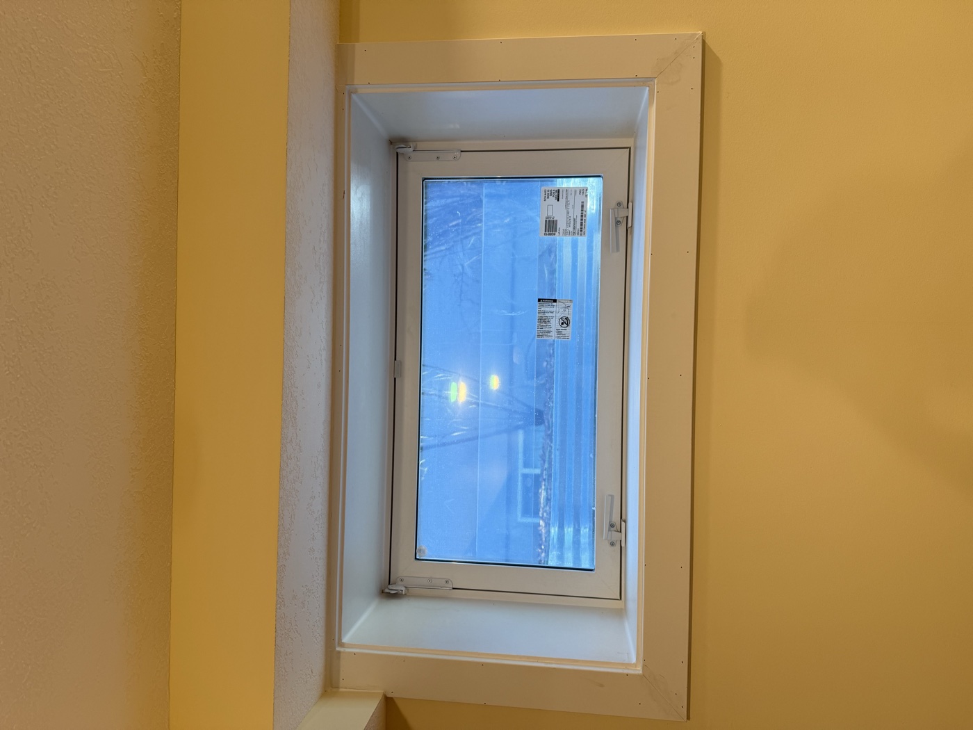 Finished interior egress window in legal suite bedroom — white trim Calgary