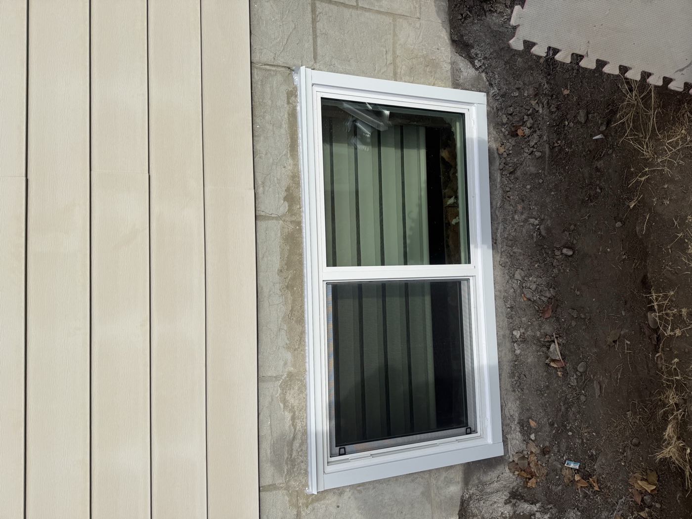 Egress slider window with galvanized well — Calgary home