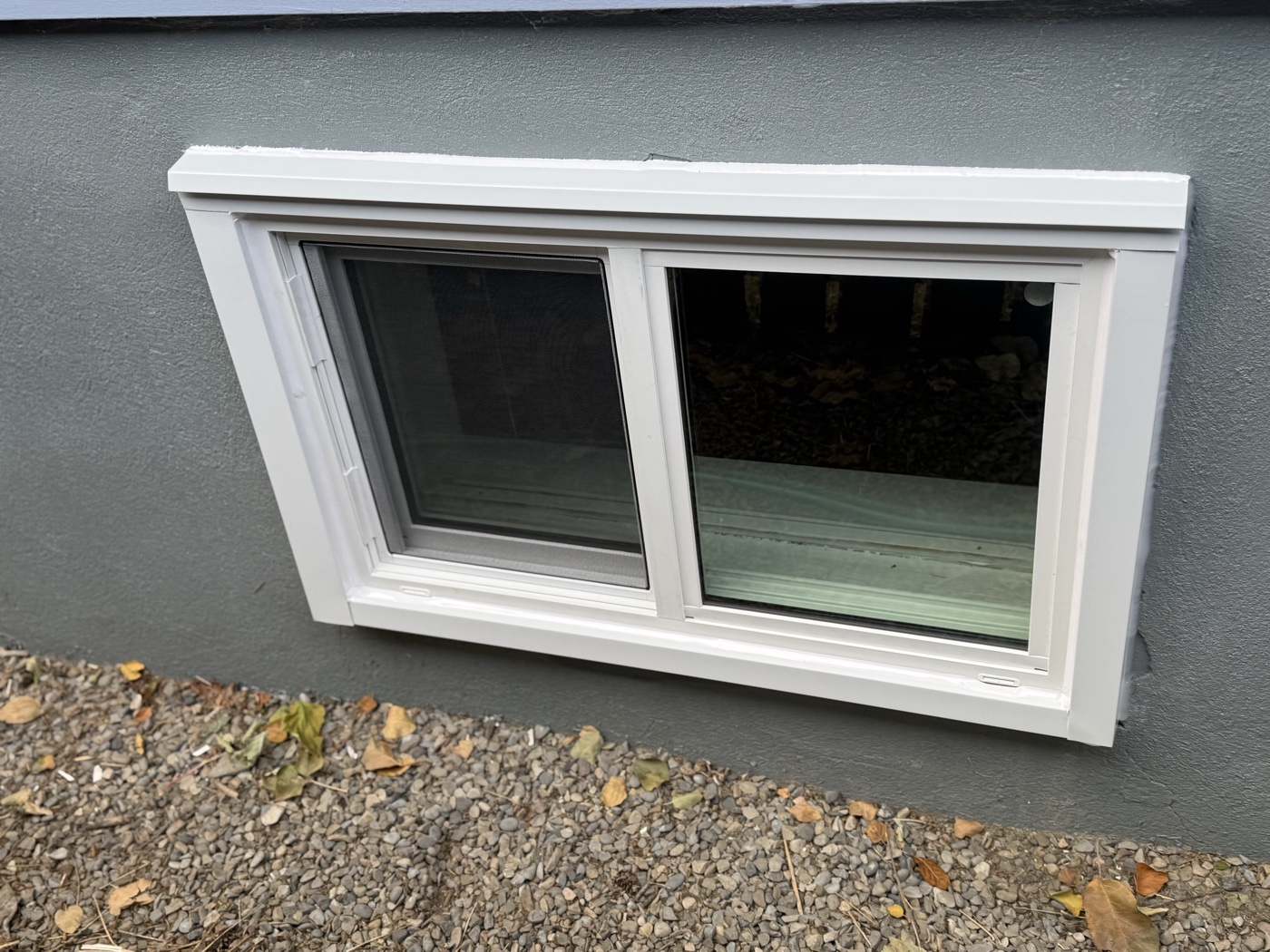 Completed egress sliding window installation exterior — Calgary